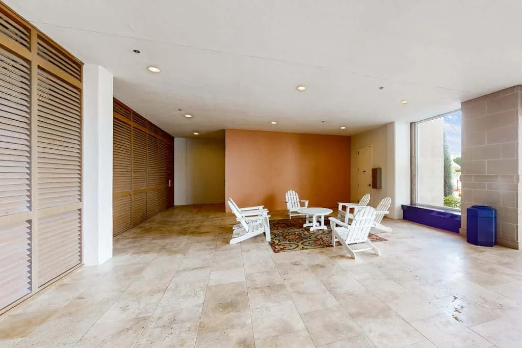 An open indoor seating area with white chairs around a small table.