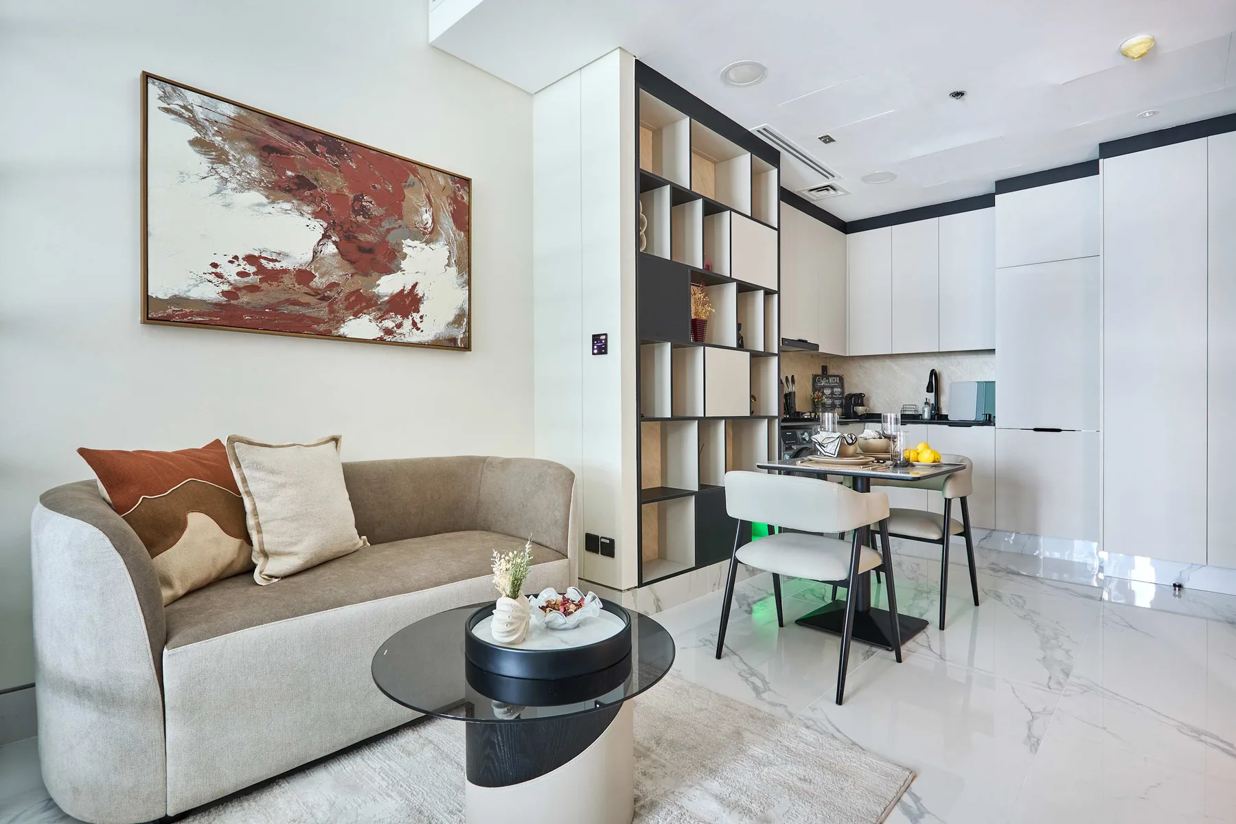 Una luminosa sala de estar con asientos junto a una cocina abierta y una mesa de comedor.