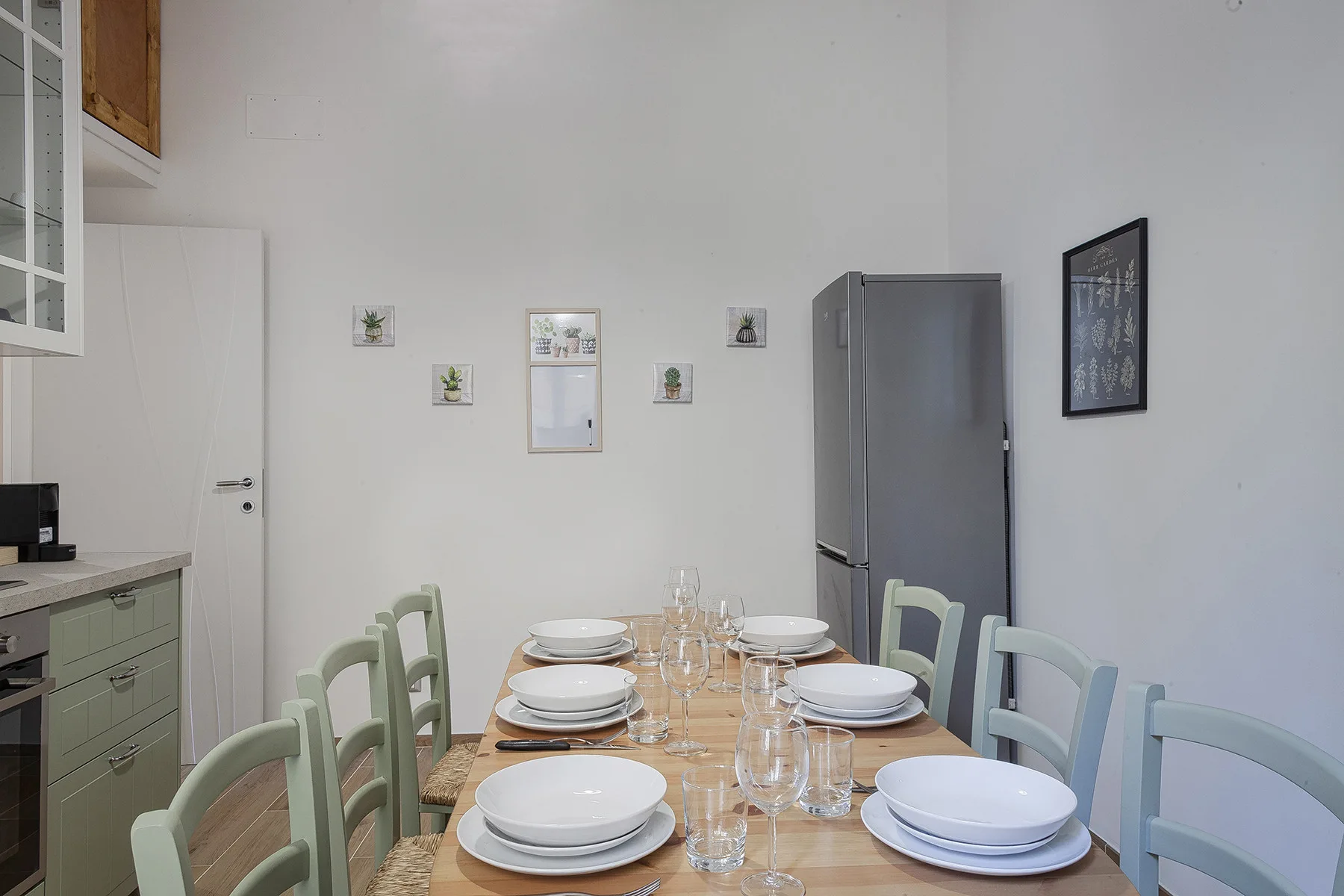 Comedor con una mesa larga puesta con platos y cristalería.