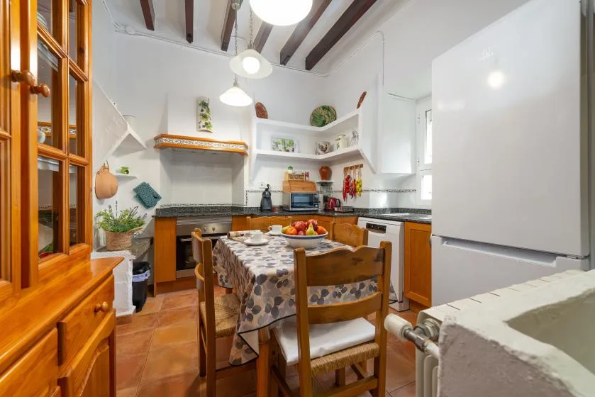 Una cocina y comedor con una mesa y gabinetes de madera.