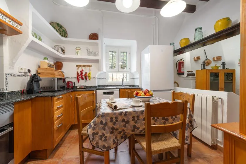 Una cocina y comedor con gabinetes de madera, una mesa y sillas.
