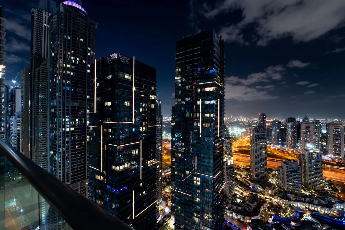Nighttime city skyline with illuminated high-rise buildings and streets.
