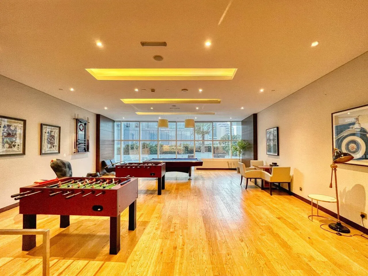A bright recreation room with pool tables and large windows.