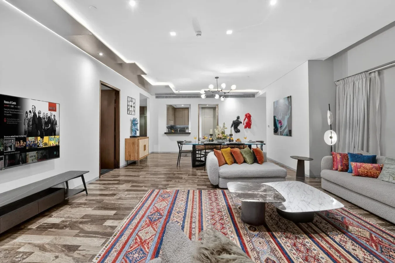 A bright living room with seating, a coffee table, and a patterned rug.