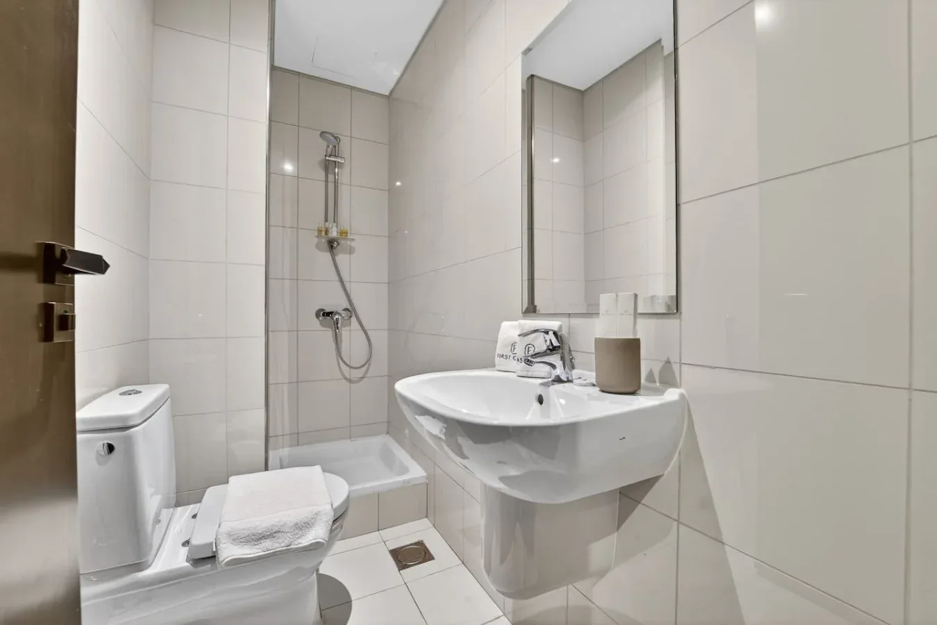 A tiled bathroom with a sink, toilet, and shower.