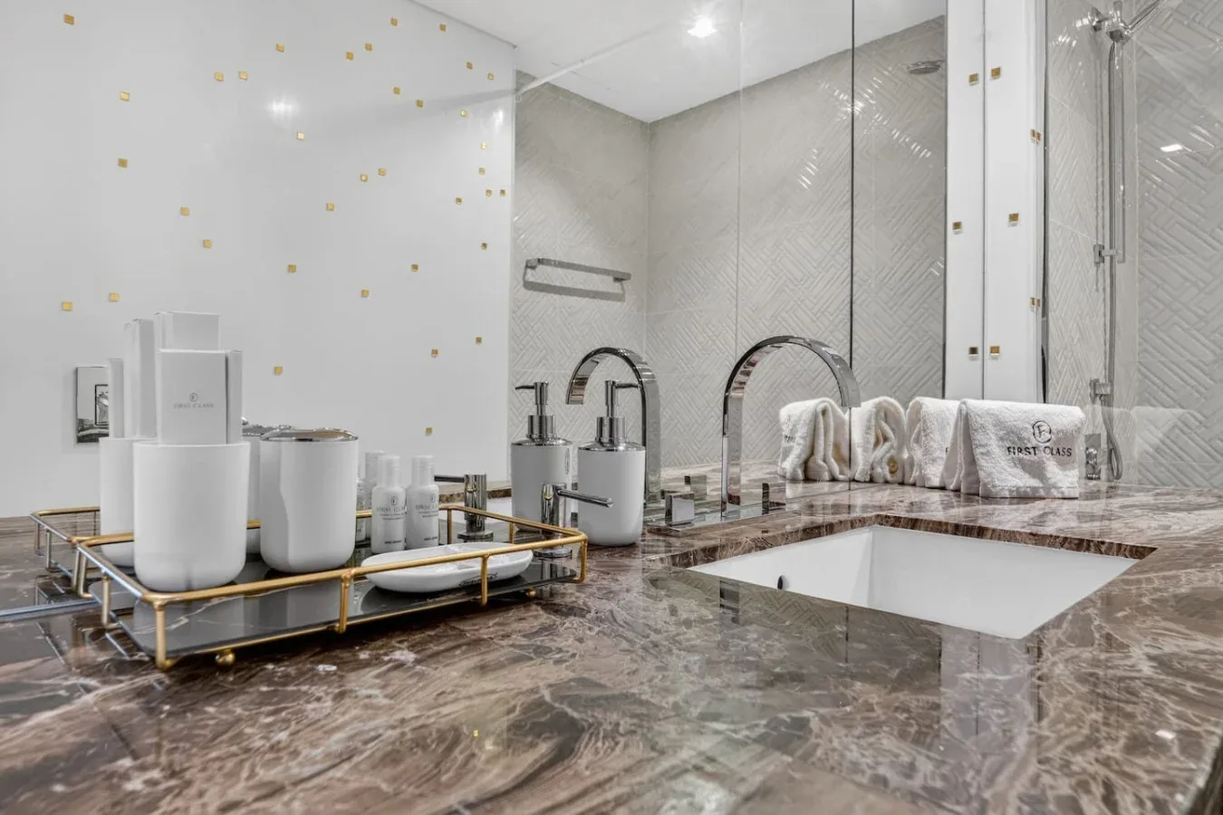 A modern bathroom vanity with sinks, toiletries, and a large wall mirror.