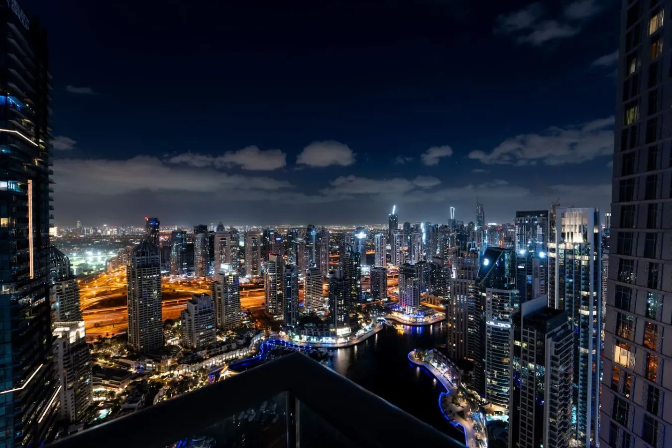 Un horizonte urbano nocturno brilla con edificios y calles iluminados.