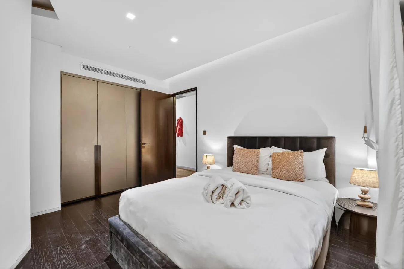 A bright bedroom with a neatly made bed and built-in wardrobes.