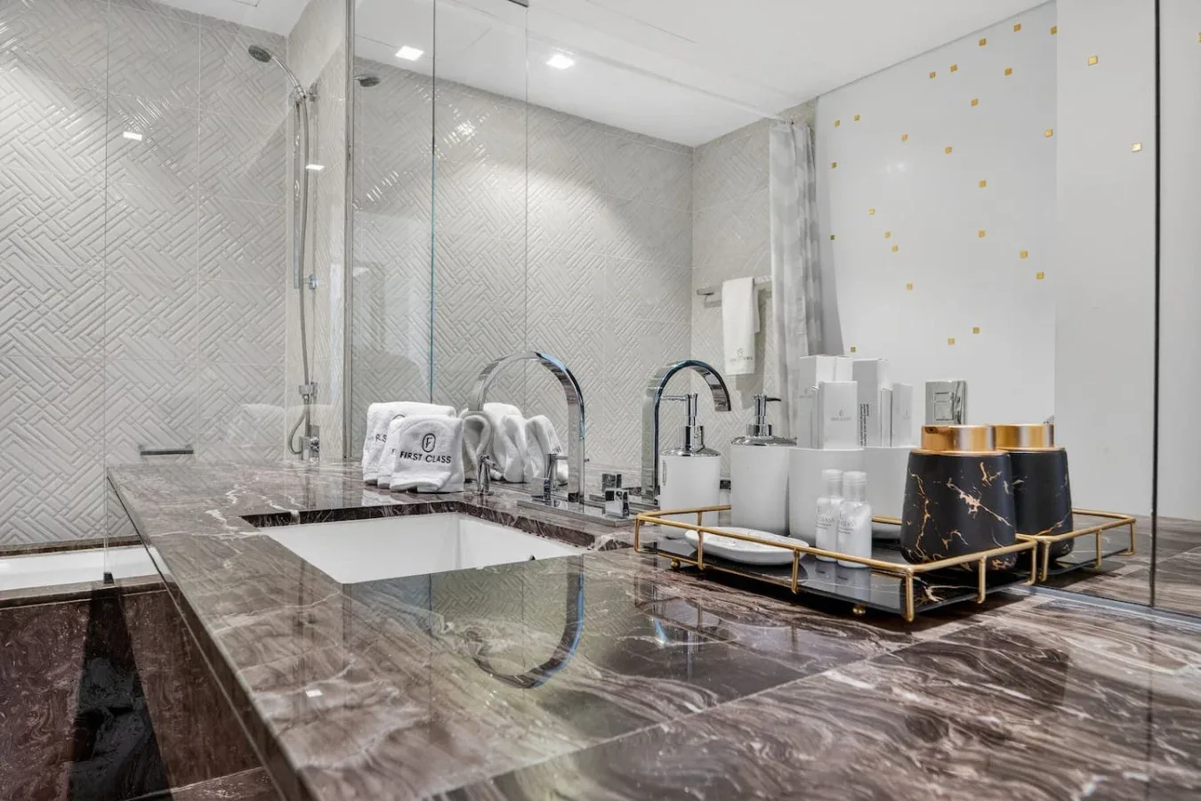 A modern bathroom with a large bathtub, glass shower, and vanity counter.