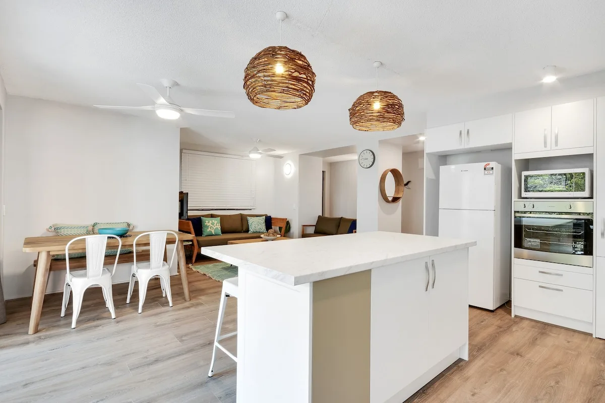 Una luminosa cocina-comedor de concepto abierto con una isla grande.