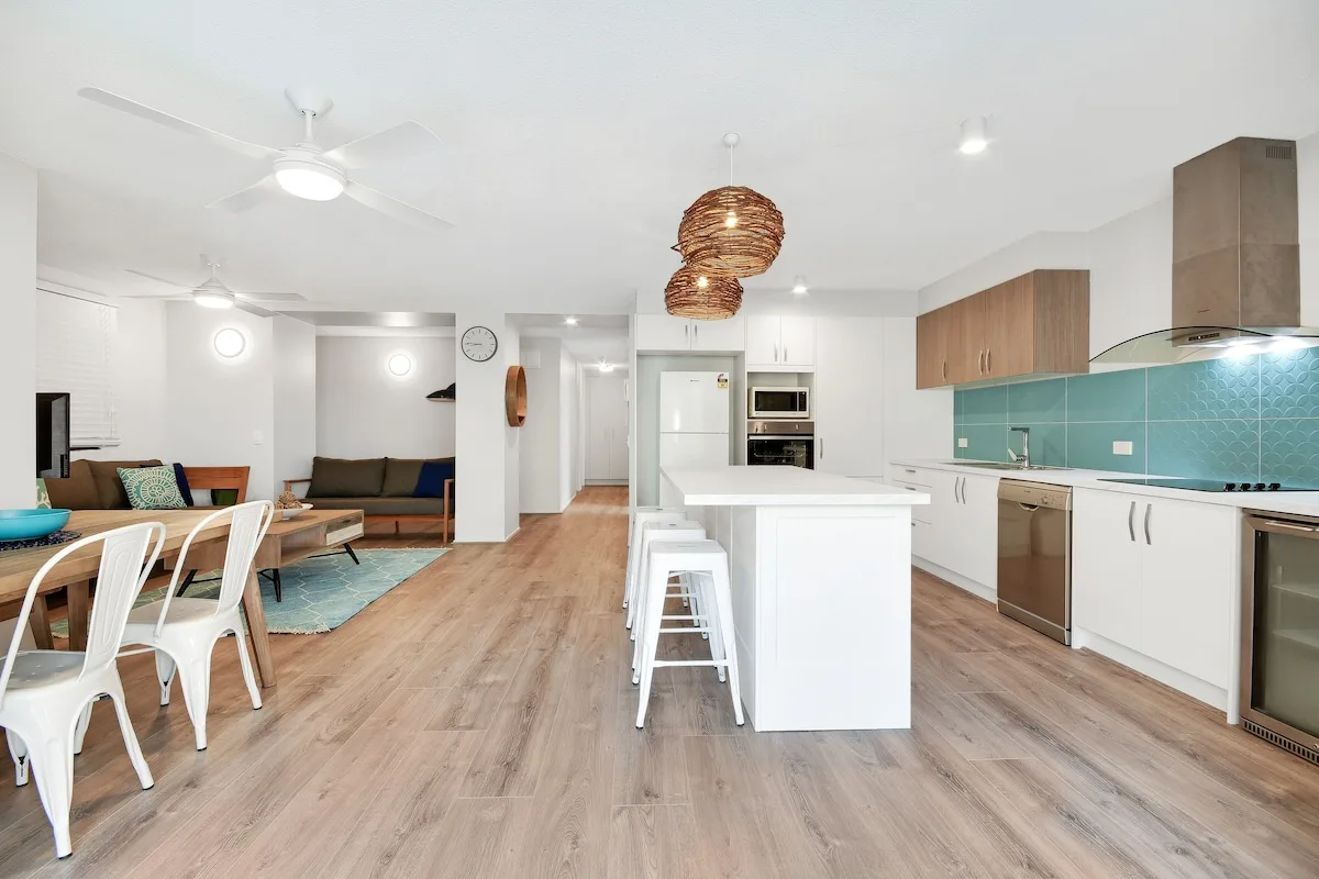 Cocina y comedor de planta abierta, con una zona de estar al fondo.