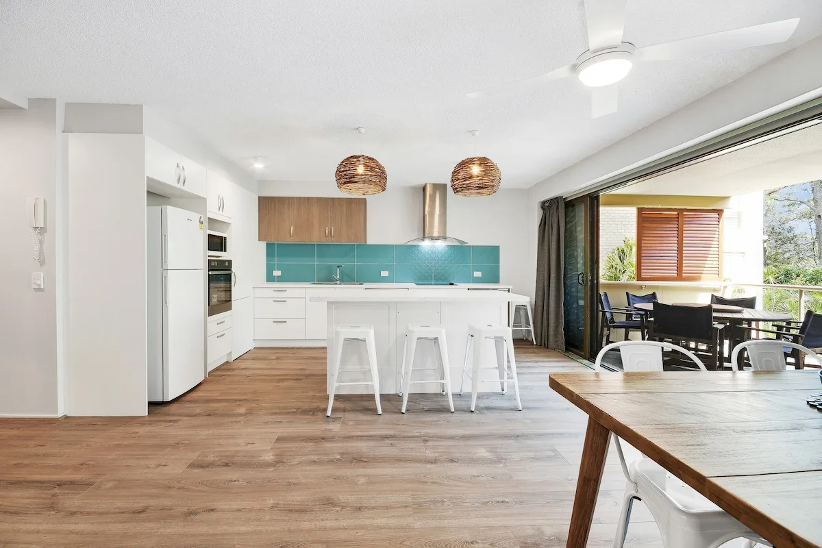 An open-plan kitchen and dining area has a breakfast bar and opens onto a balcony.
