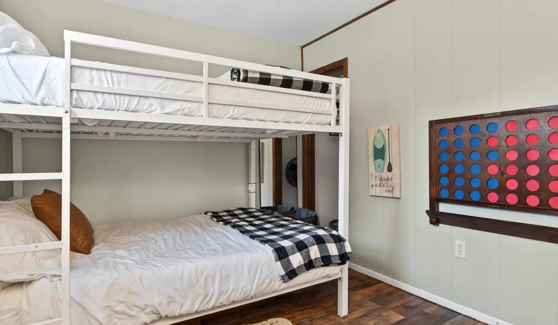 A bedroom with white bunk beds and black-and-white bedding.
