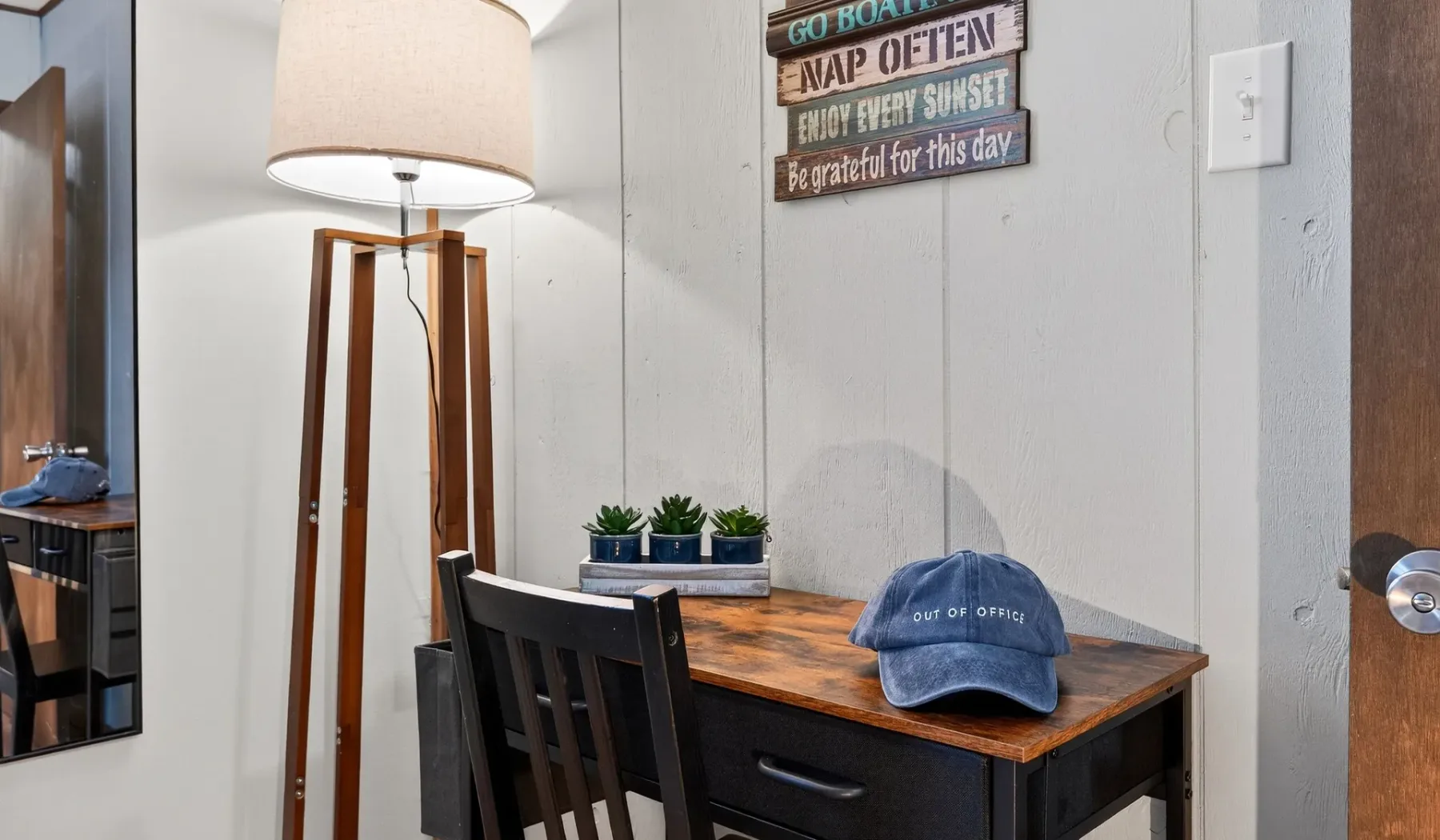 A small dining area with a wooden table, chairs, and a floor lamp.