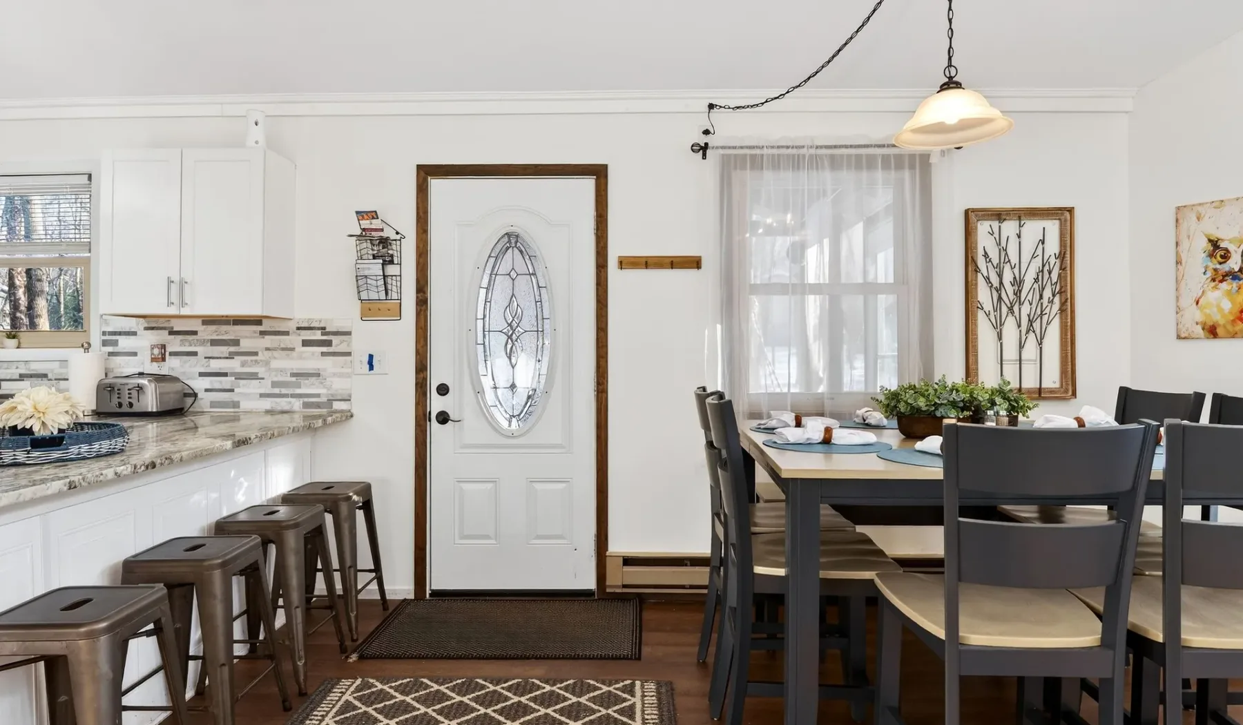 A bright kitchen and dining area with a table beside the window.