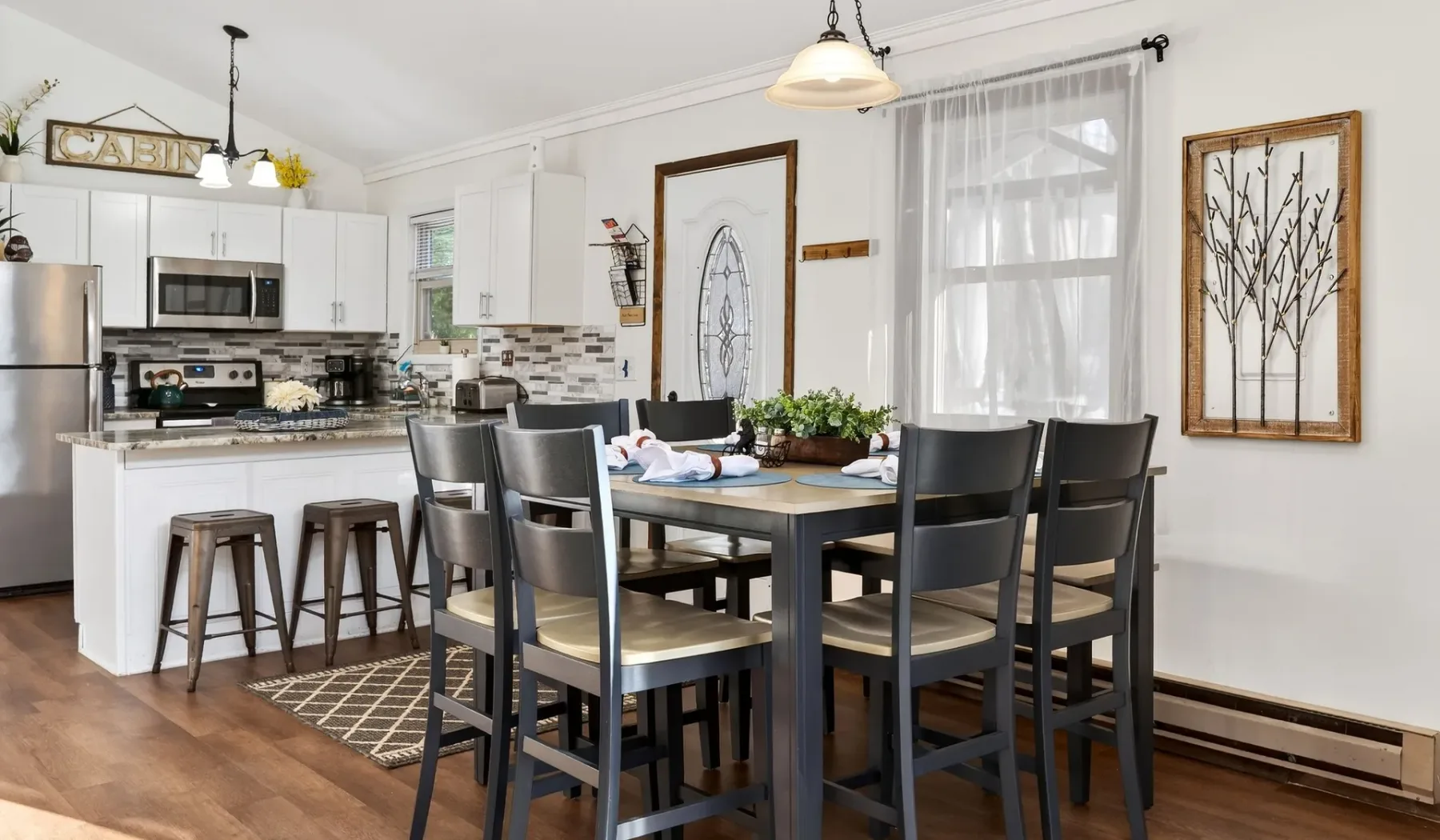 A dining area with a table and chairs beside a bright kitchen.