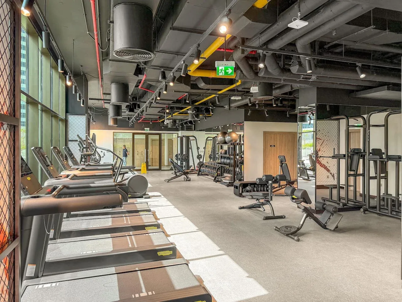 A gym with treadmills along the windows and exercise equipment across the room.