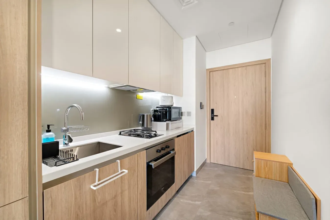 A compact kitchen with wood cabinetry, a countertop, and a cooking range.