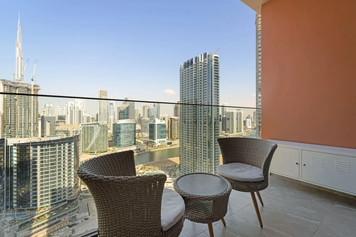 A balcony seating area overlooks a city skyline.