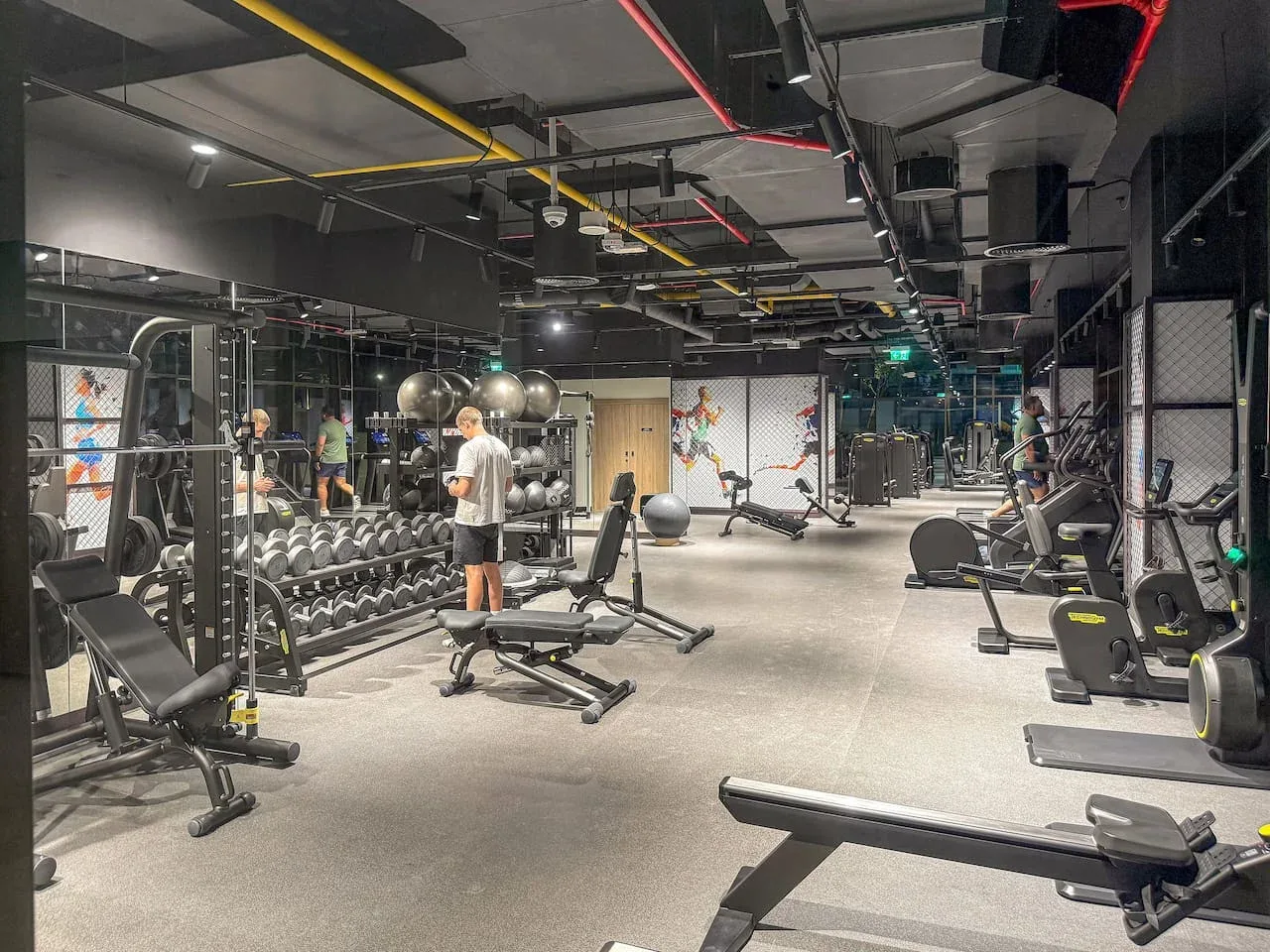 A gym with rows of weights, exercise machines, and workout benches.
