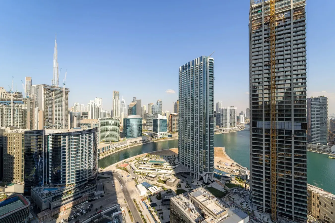 A city skyline of high-rise buildings surrounds a curving waterfront.