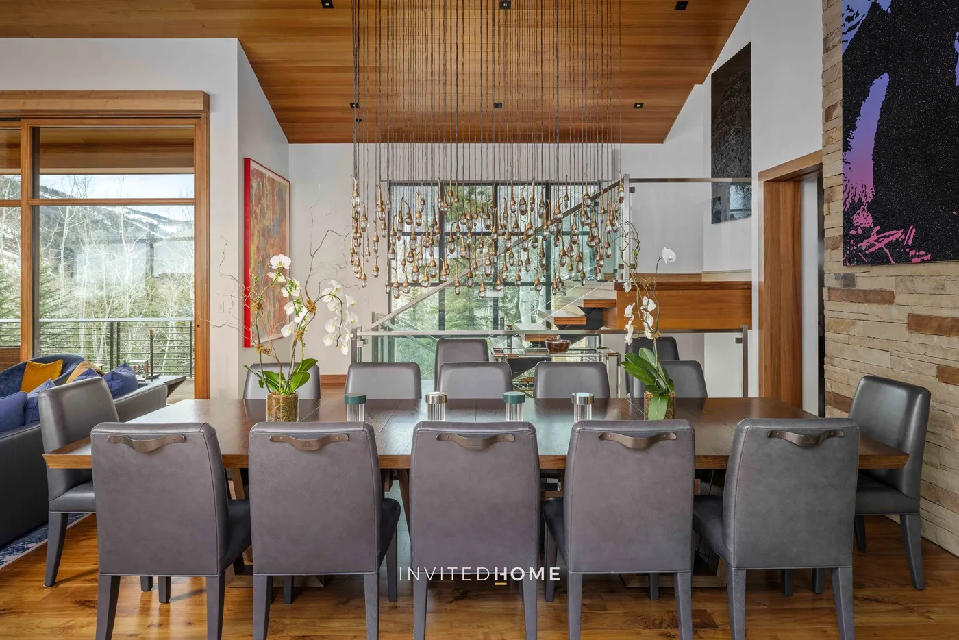 Comedor con una mesa larga y asientos tapizados bajo un techo de madera.