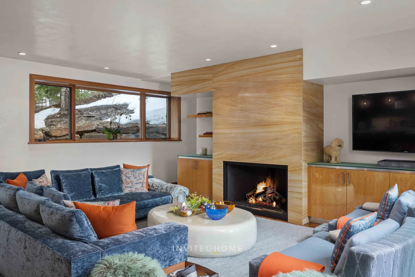 Una sala de estar con asientos alrededor de una chimenea y una mesa de centro.
