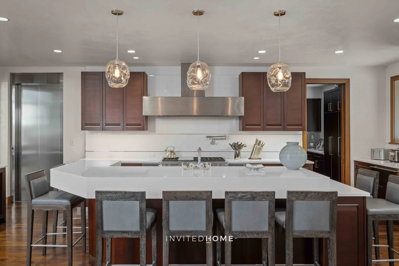 Una cocina moderna con una isla grande y luces colgantes.