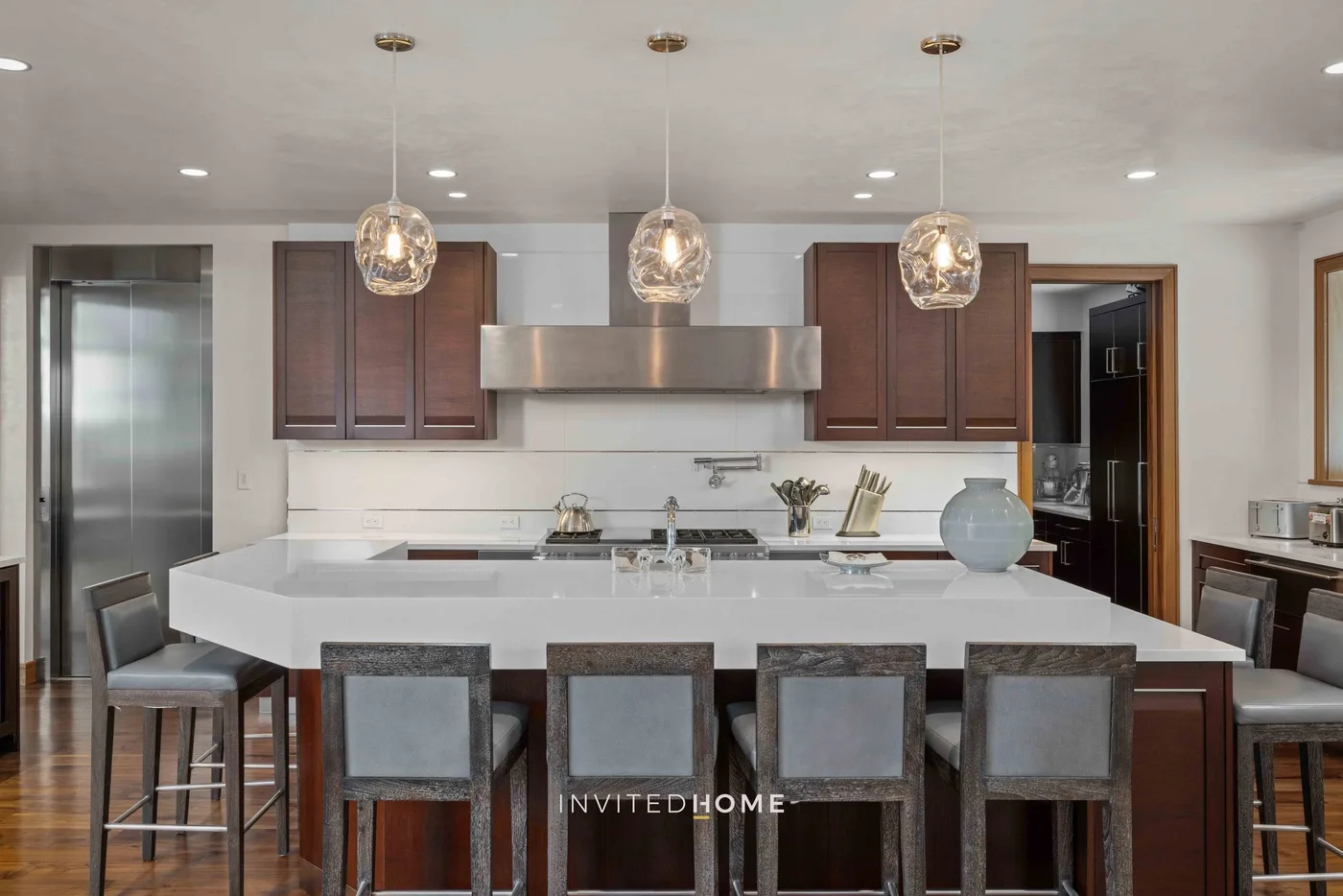 Una cocina moderna con una isla grande y lámparas colgantes.