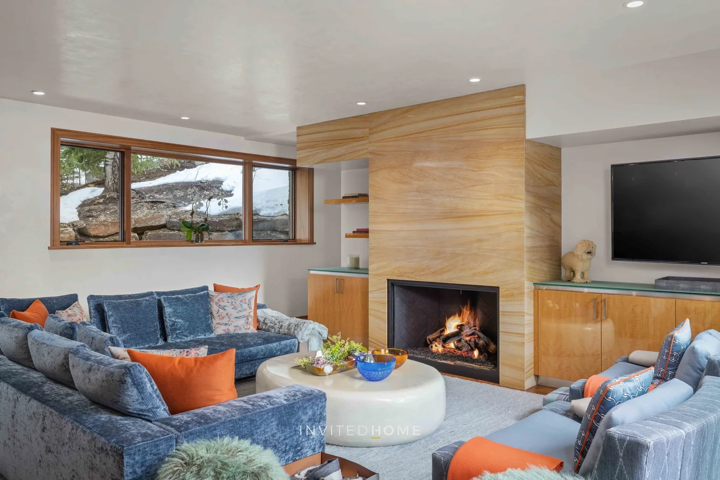 Una sala de estar con asientos dispuestos alrededor de una chimenea y una mesa de centro.