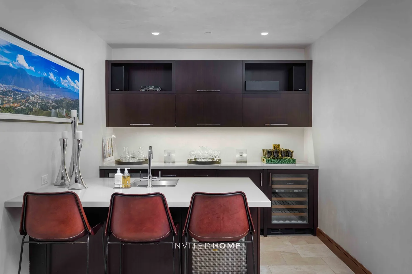Una zona de comedor moderna tiene un mueble empotrado oscuro y una encimera larga con asientos.