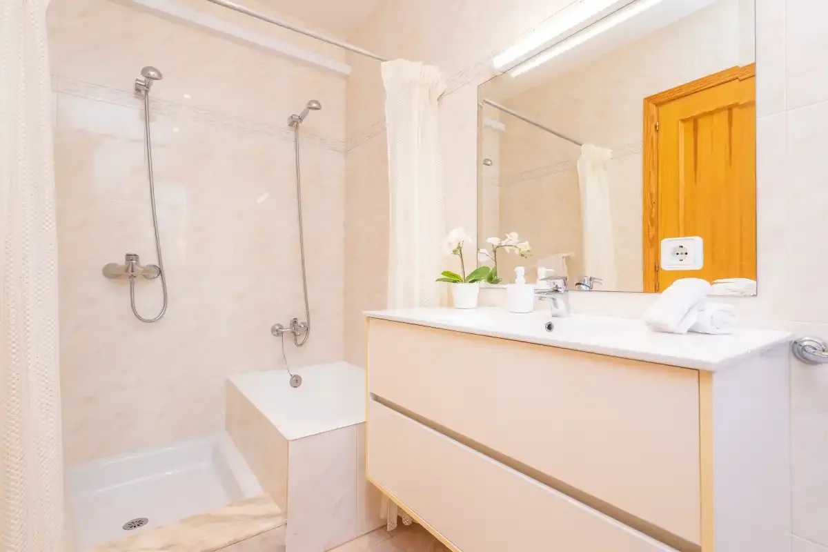 A bright bathroom with a shower, bathtub, and vanity.