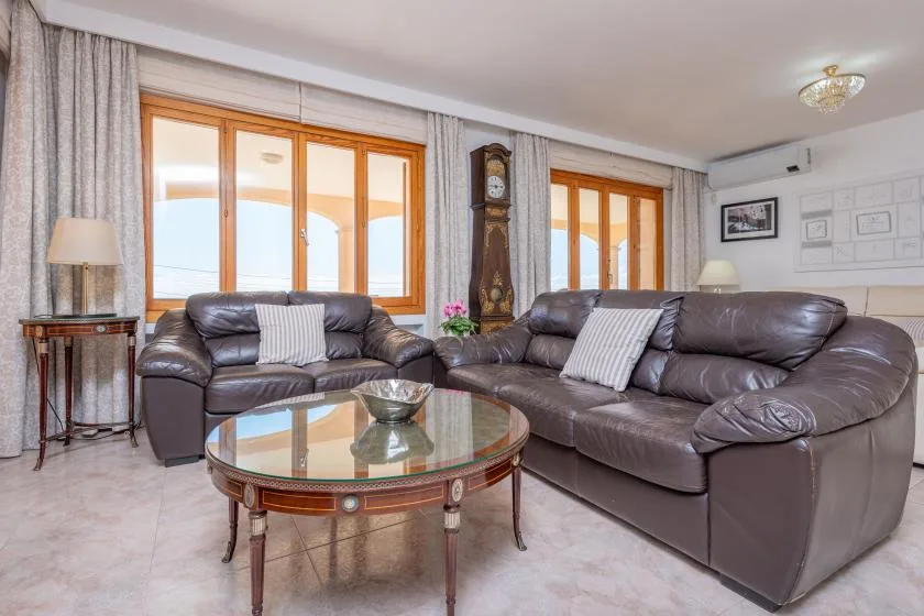 A living room with leather seating and a glass-topped coffee table.