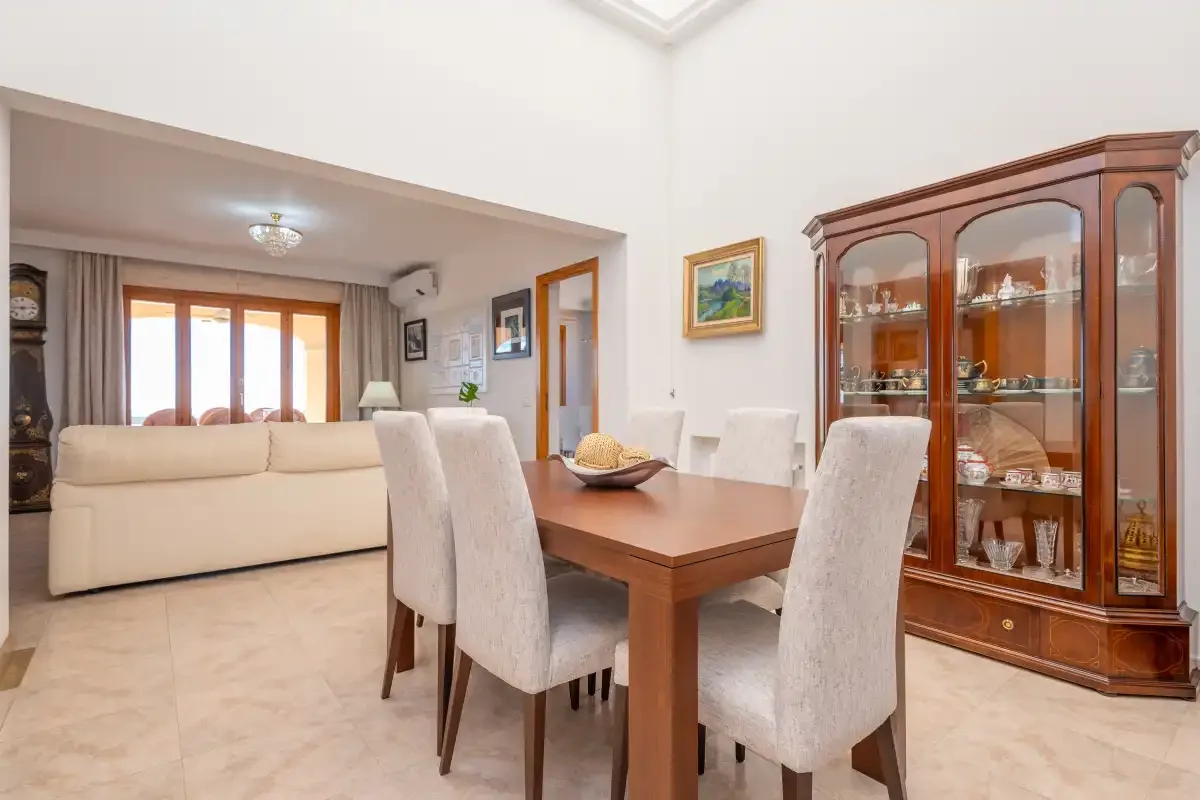 A dining area with upholstered seating and a glass-front display cabinet.
