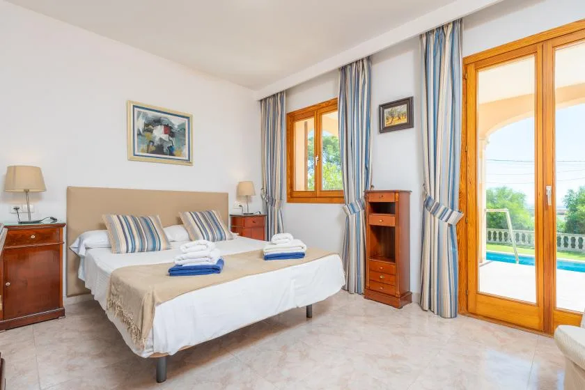 A bedroom with a double bed and glass doors opening onto a balcony.