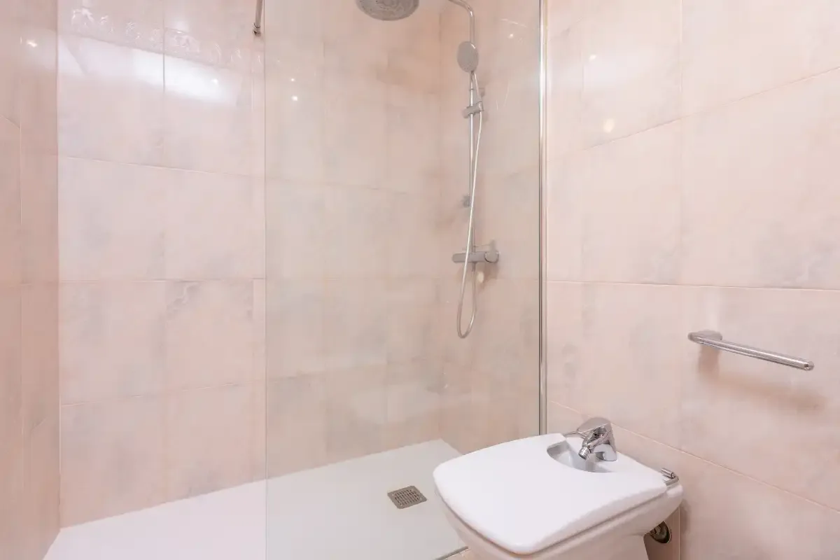 A tiled bathroom with a shower and sink.
