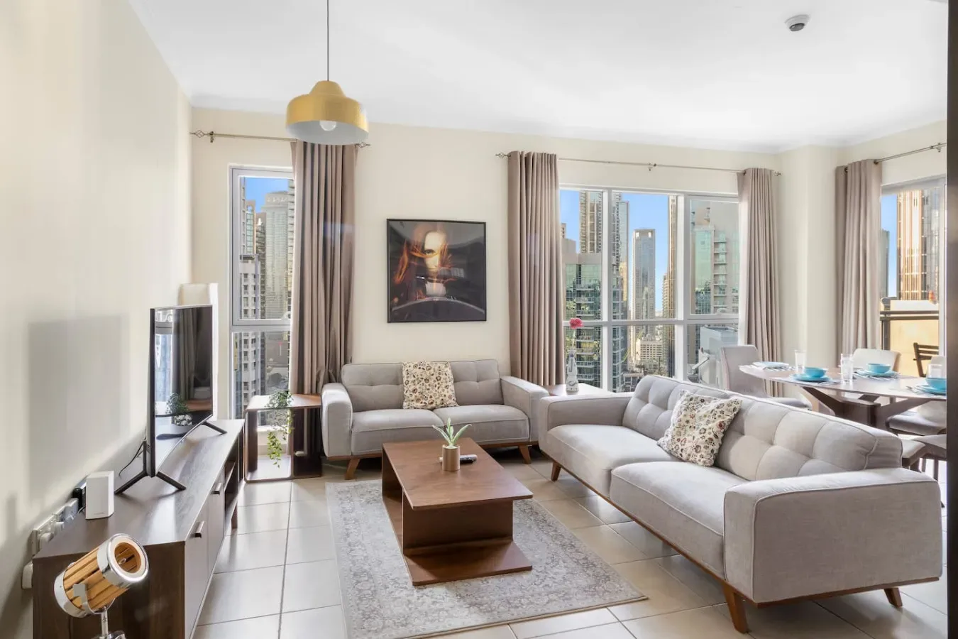 A bright living room with seating, large windows, and a coffee table.
