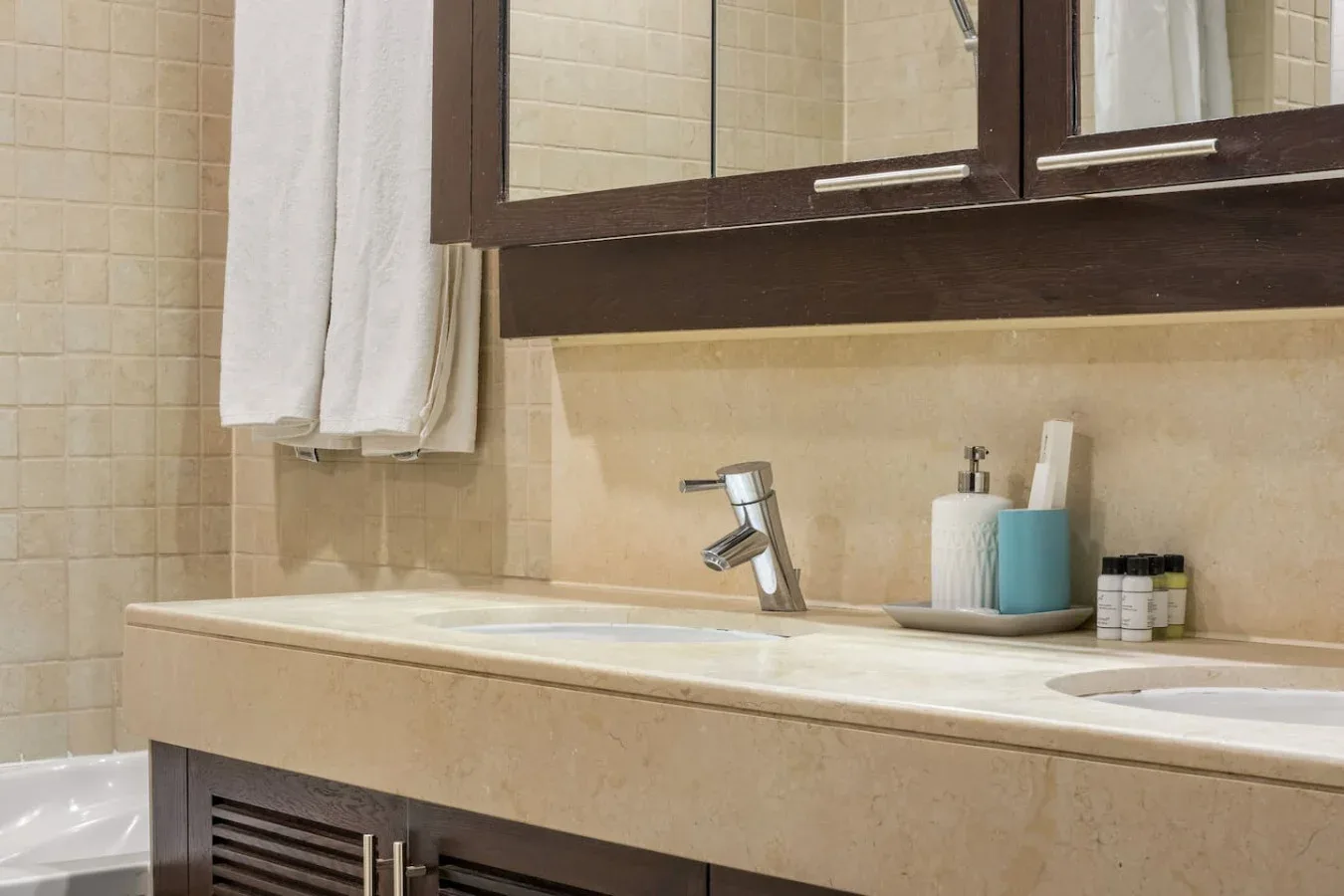 A bathroom vanity with a sink, toiletries, and a large mirror.