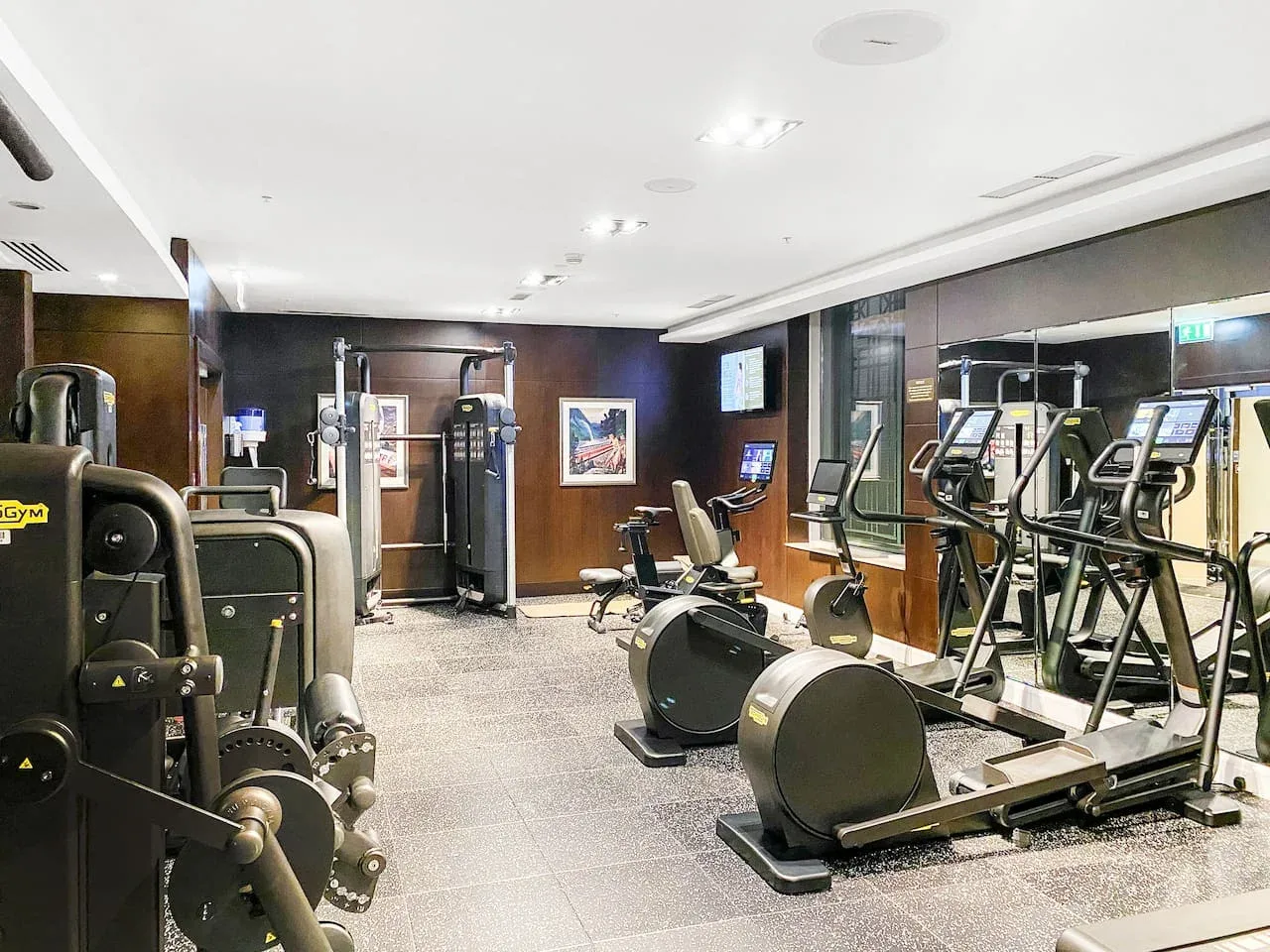 A gym with exercise machines and cardio equipment arranged across the room.