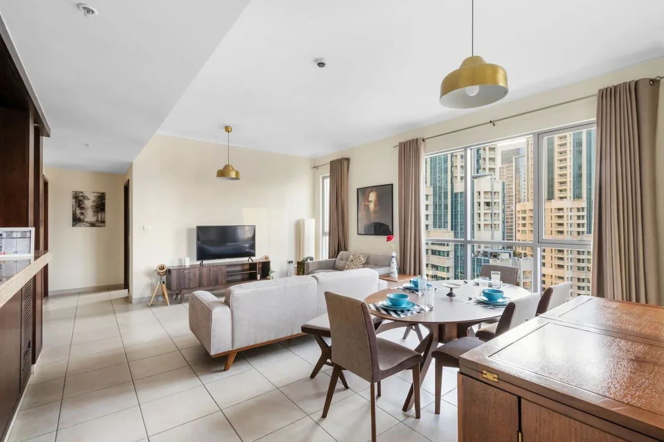 A bright living and dining area with seating beside large windows.