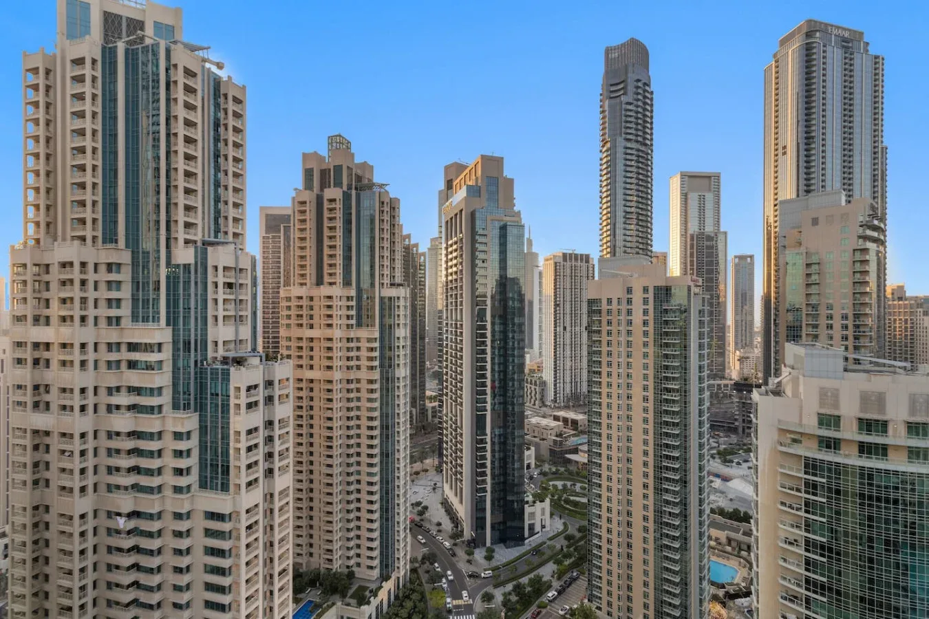 A dense cluster of high-rise buildings fills the city skyline beneath a clear blue sky.