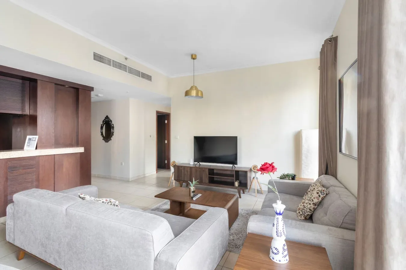 A bright living room with seating, a television, and a wooden coffee table.