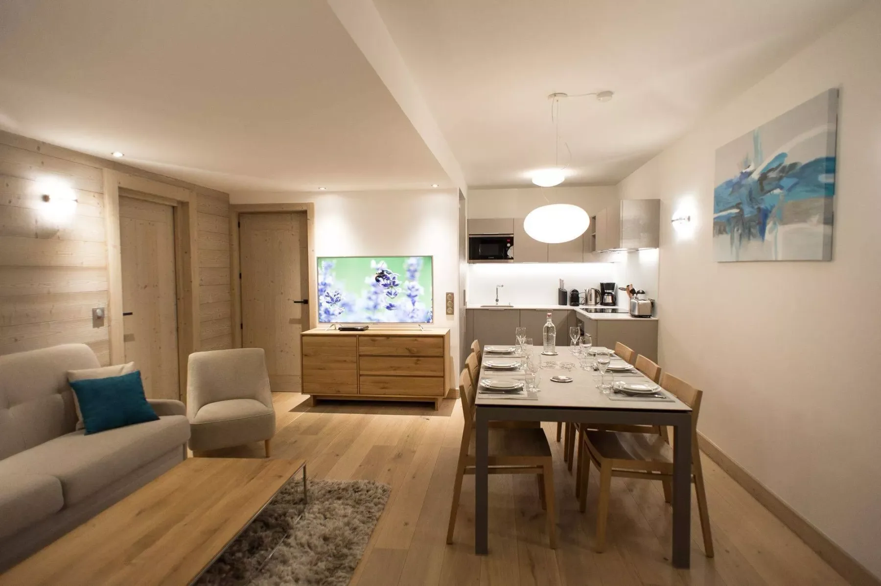 Sala de estar y comedor con sofá, mesa de comedor y cocina abierta.