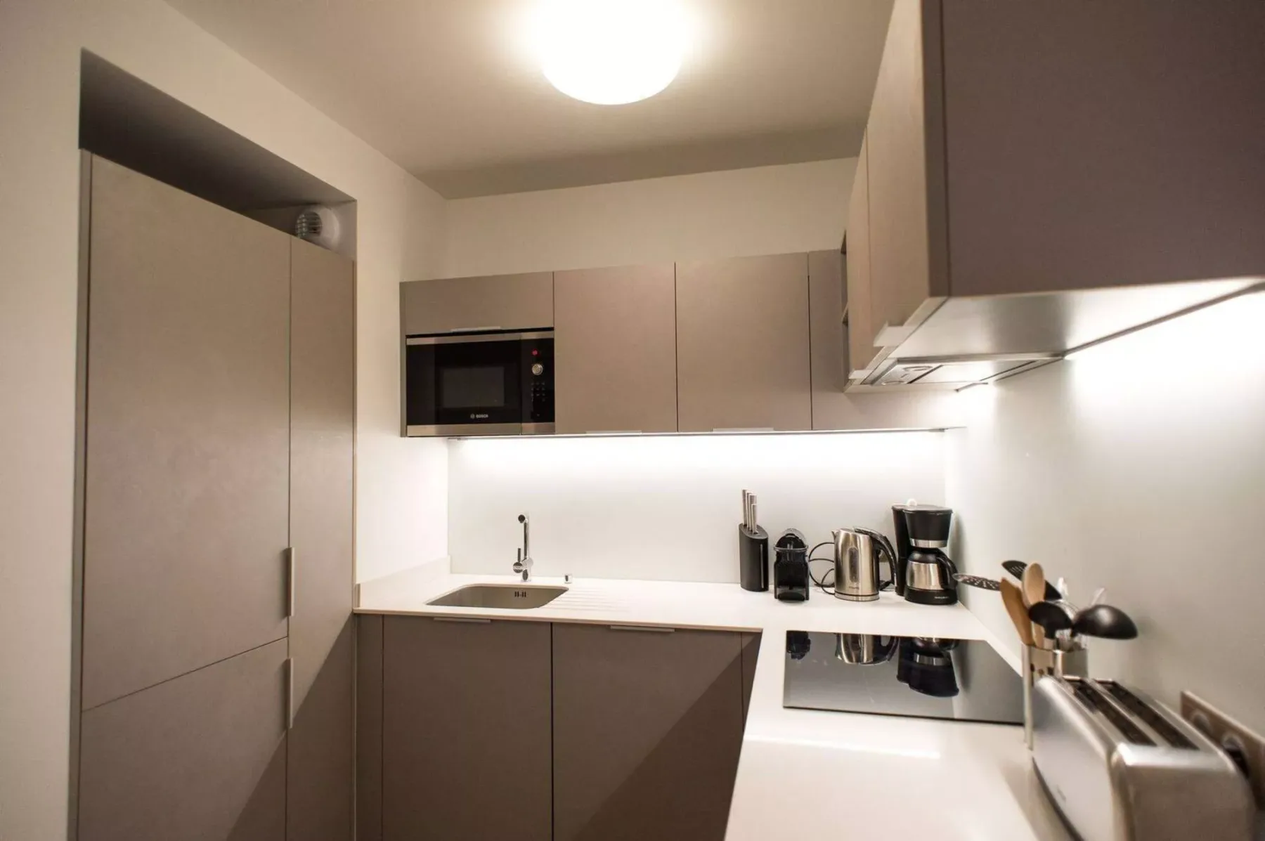 A compact kitchen with pale cabinetry and a countertop.