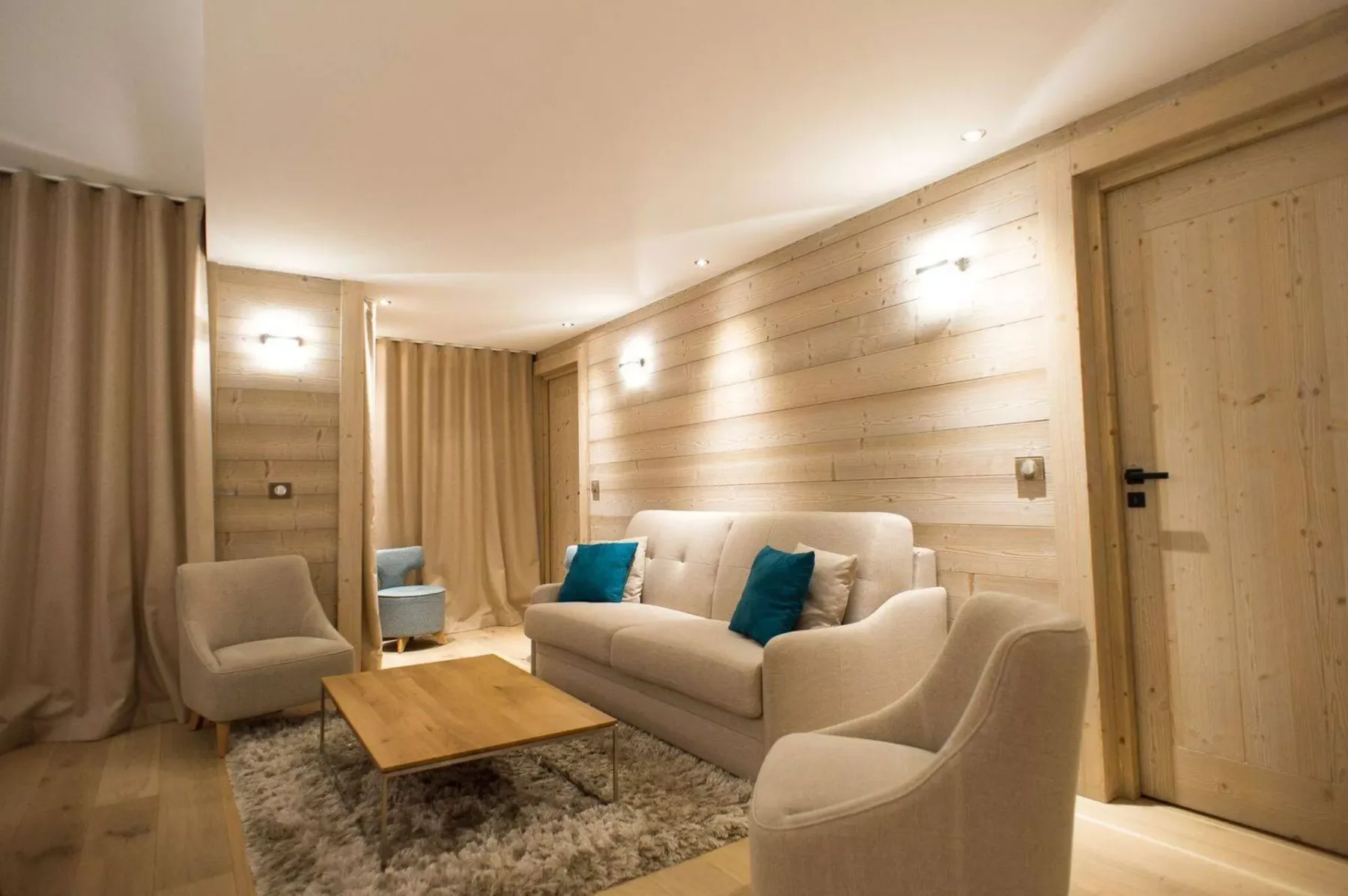 A living room with seating, a wooden coffee table, and beige curtains.