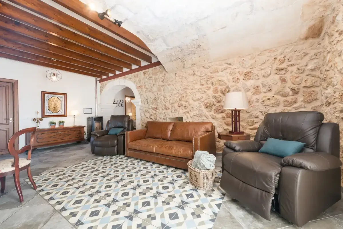 Un salón con asientos de cuero, vigas de madera en el techo y suelo de baldosas estampadas.