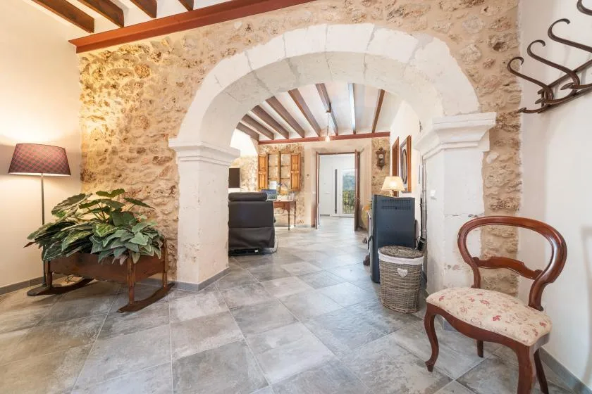Una sala de estar con paredes de piedra, un arco y asientos.