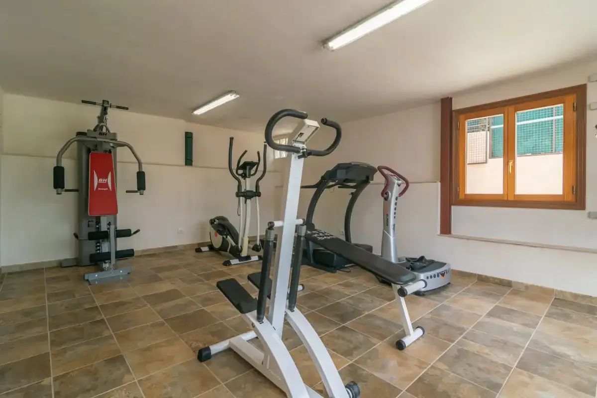 Una sala de ejercicio con máquinas y una ventana.