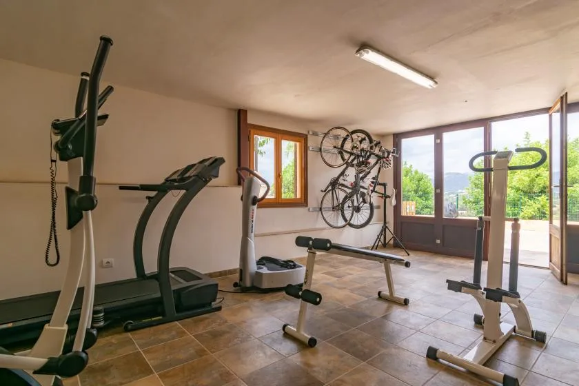 Un gimnasio con equipo de ejercicio y bicicletas montadas en la pared.