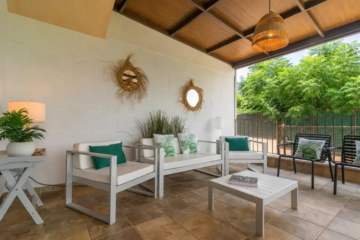 Una zona de estar exterior cubierta con una mesa de centro y vistas al jardín.